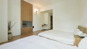 A modern hotel room with two beds, a flat-screen TV mounted on the wall, a small bedside table with a phone, and a potted plant. - Raise Hotel Taichung (Taichung)