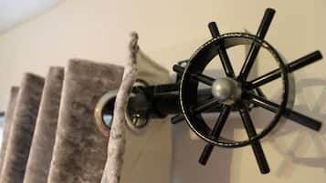A wall-mounted ship's wheel light fixture with a textured wall behind it.