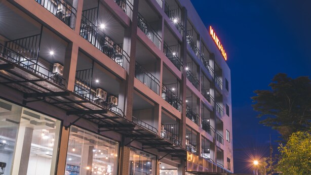 A multi-story hotel with balconies, a swimming pool, and a restaurant.