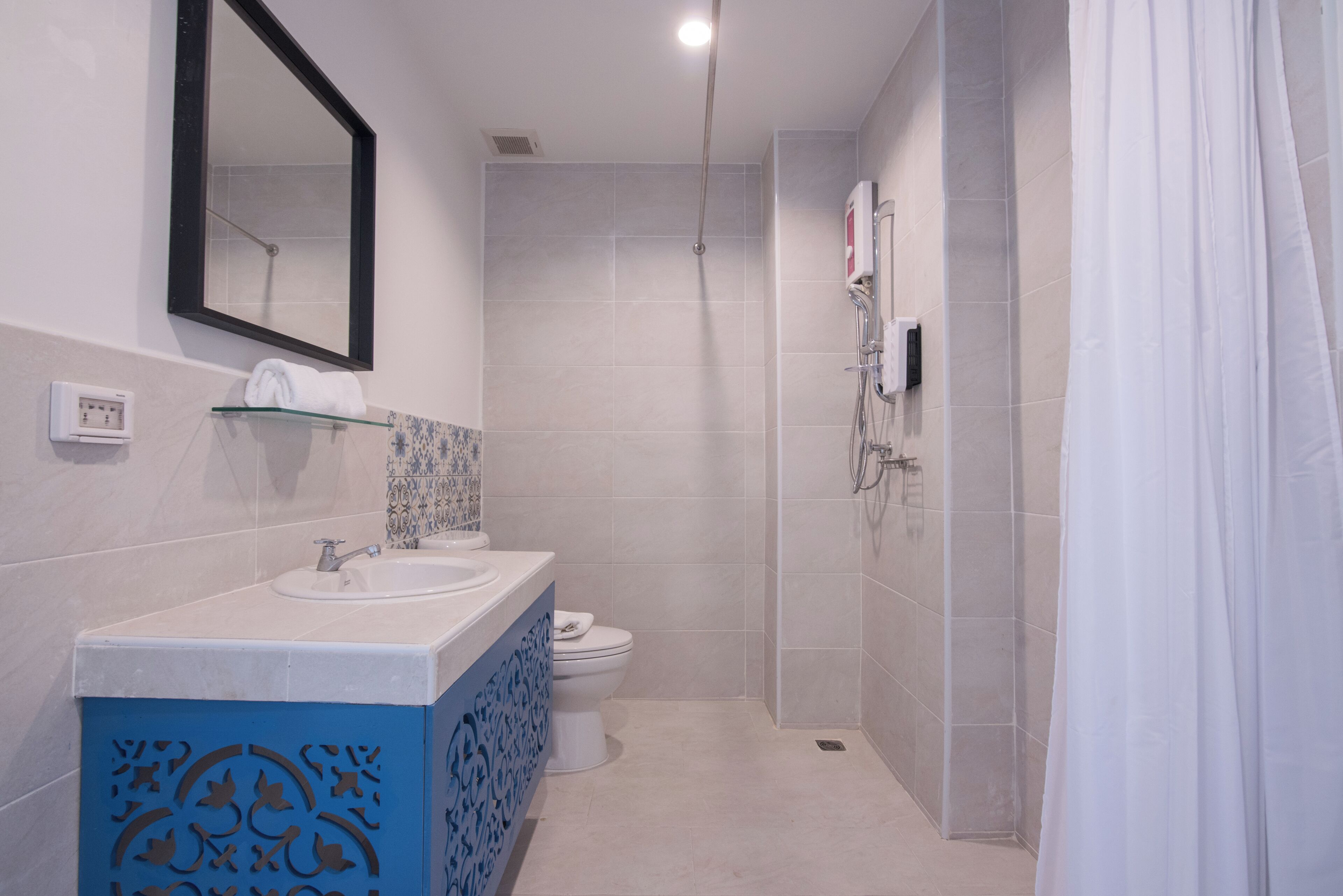 A modern bathroom with a white sink, a toilet, and a shower area.