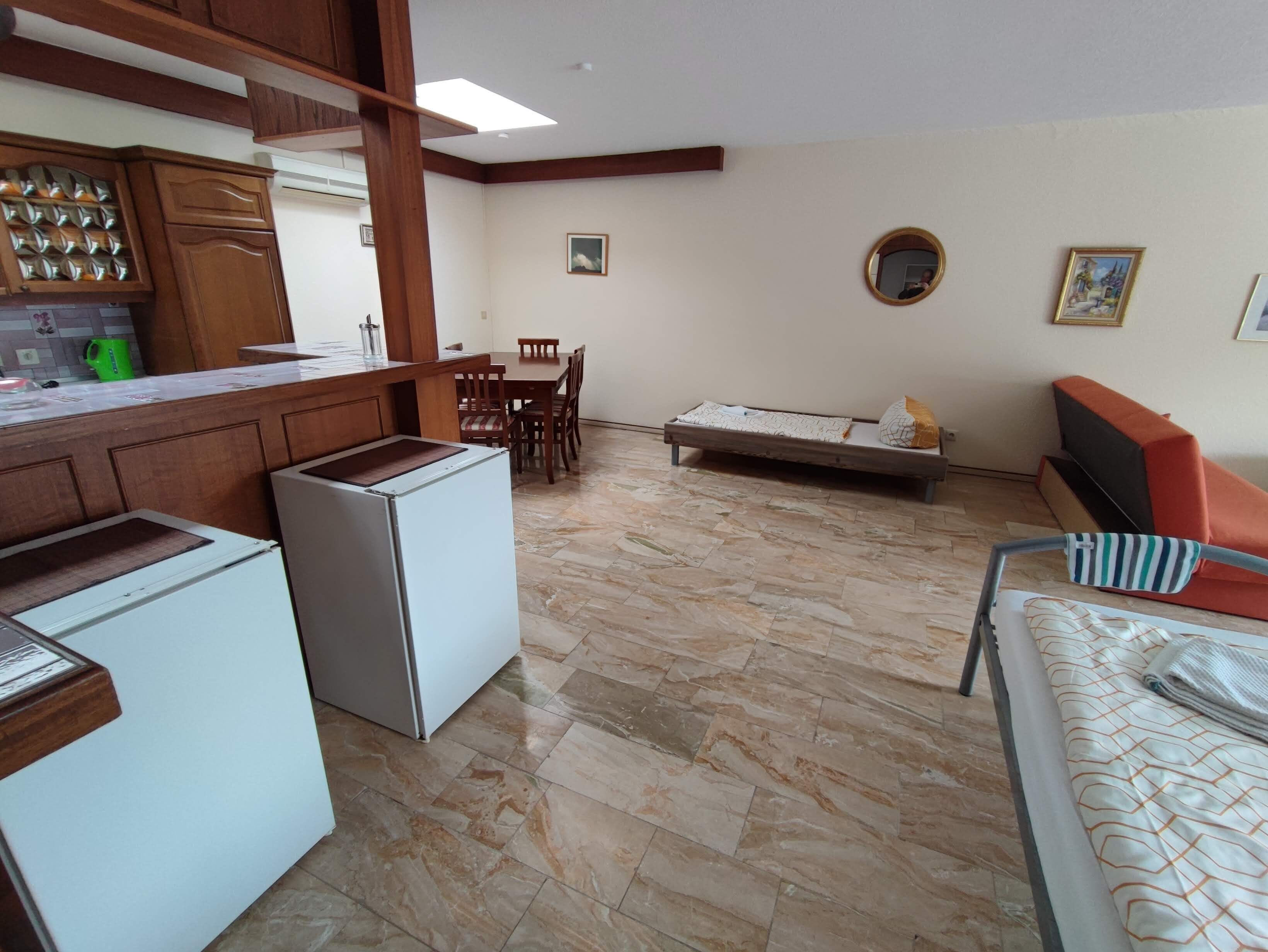 Un espacio habitable compacto con kitchenette, comedor y sofá.