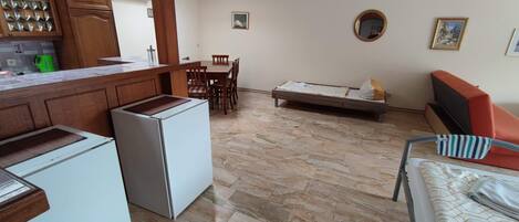 Un espacio habitable compacto con kitchenette, comedor y sofá.