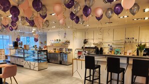 A modern restaurant with a bar area, a display case with food items, and a counter with a menu. - Hotel Schiff (Rastatt)
