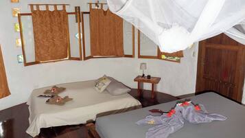Quarto com duas camas, uma mesinha com abajur e uma porta de madeira.