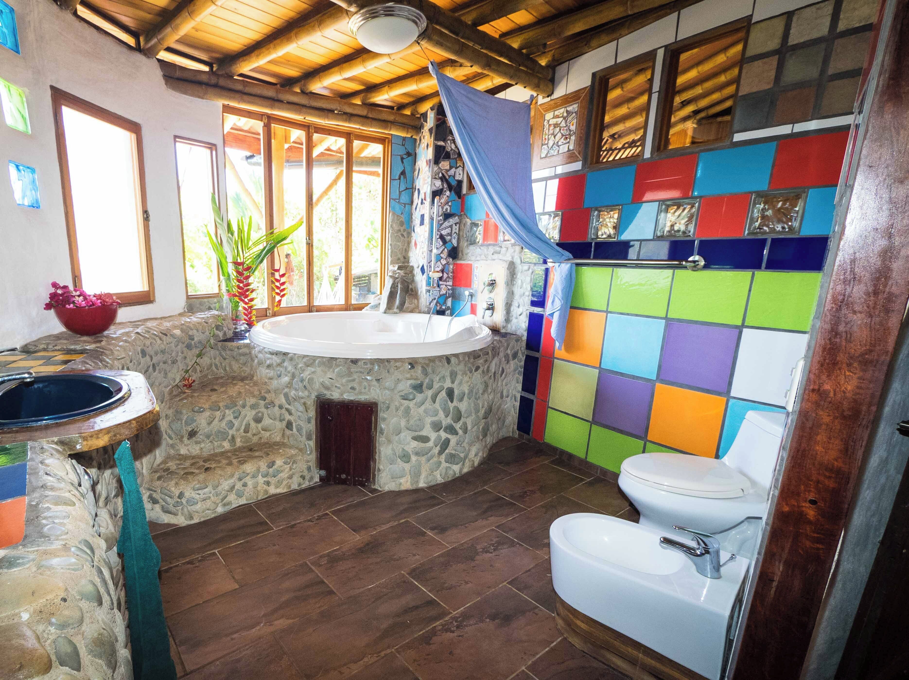 A bathroom with a stone sink, a bathtub, and a toilet.