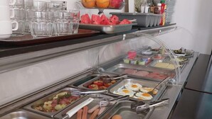 A buffet with various food options including eggs, sausages, and sliced vegetables. - Boutique Hotel Arka (Budva)