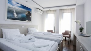 A hotel room with two beds, a desk, a chair, and a large window. - Boutique Hotel Arka (Budva)