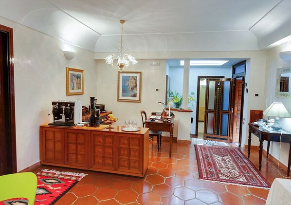 Un salón amplio con un aparador de madera, una mesa de comedor y una araña.