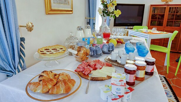 Un buffet de petit-déjeuner avec des viennoiseries, des fromages et des confitures, le tout disposé sur une table.