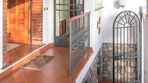 Un escalier en bois avec une rampe en métal, une porte en bois et un mur en pierre.