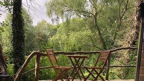 A hot tub surrounded by wooden deck steps, wooden chairs, and a wooden railing. - Herons Lake Retreat (Mold)