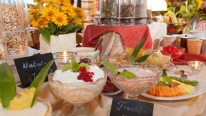 Une table de buffet avec divers plats et une pancarte sur laquelle on peut lire « Frucht ».