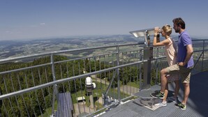 Un belvédère offrant une vue panoramique, doté d’une rambarde en métal, d’où l’on peut admirer le paysage, et sur lequel est installée une structure de panneaux solaires.