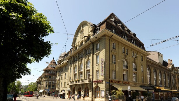 A historic building with a prominent hotel sign, multiple windows, and a tram line running in front. - Hotel National Bern (Bern)