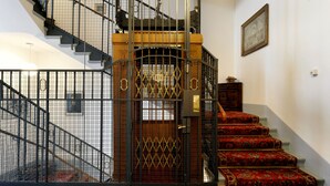 A staircase with a metal gate and red carpeted steps. - Hotel National Bern (Bern)