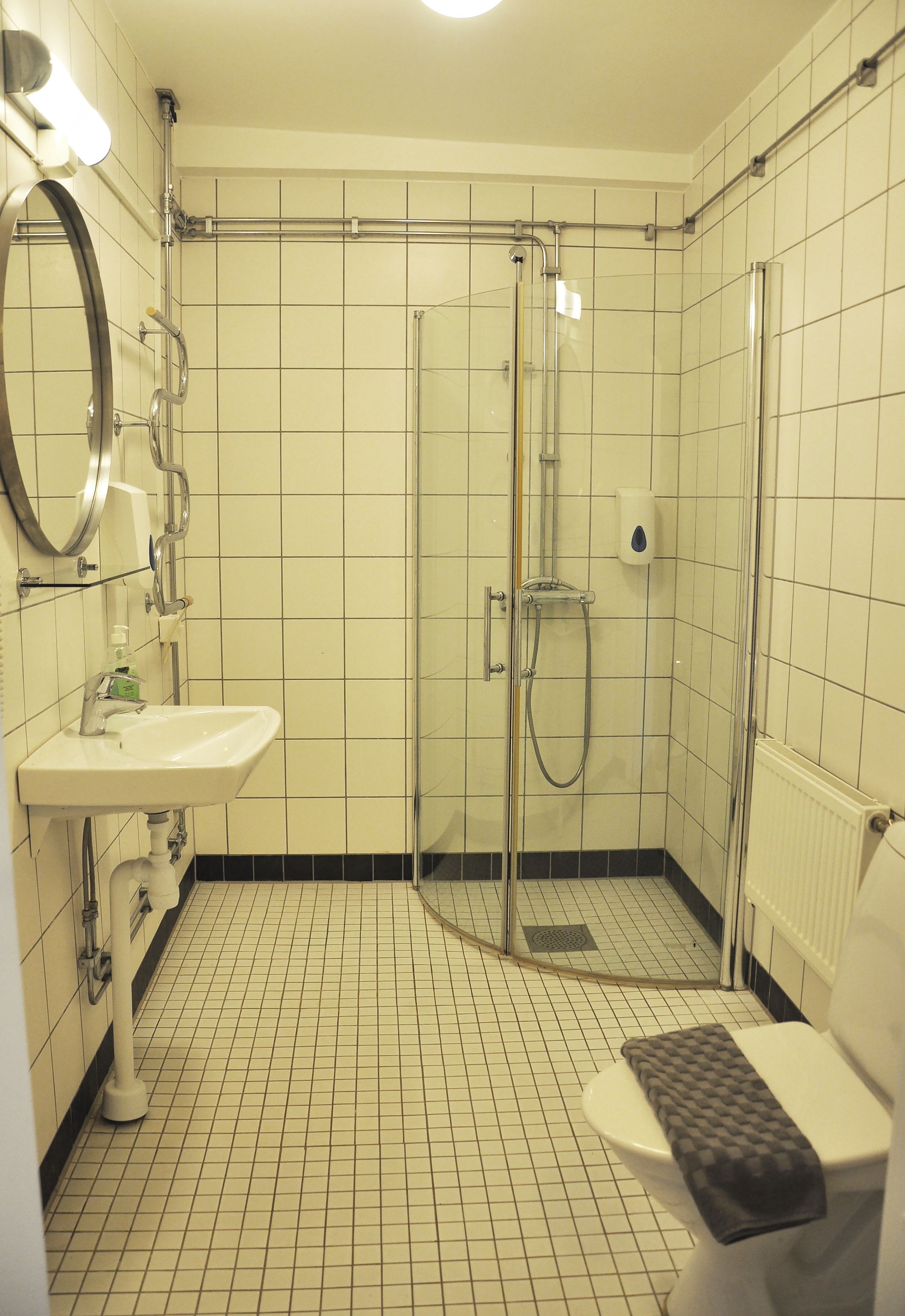 Une salle de bain équipée d’un lavabo, de toilettes et d’une douche à parois de verre.