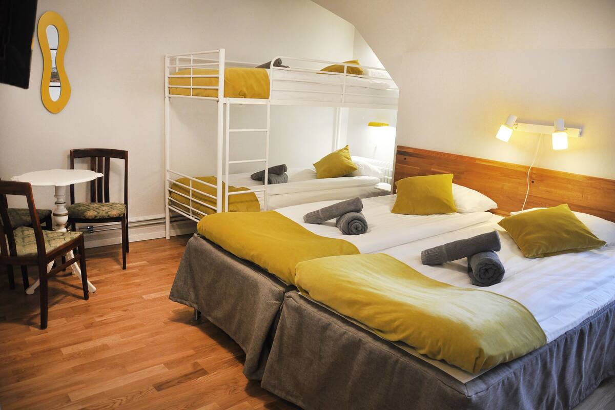 Ein Zimmer mit Etagenbetten, einem kleinen Tisch und Stühlen.