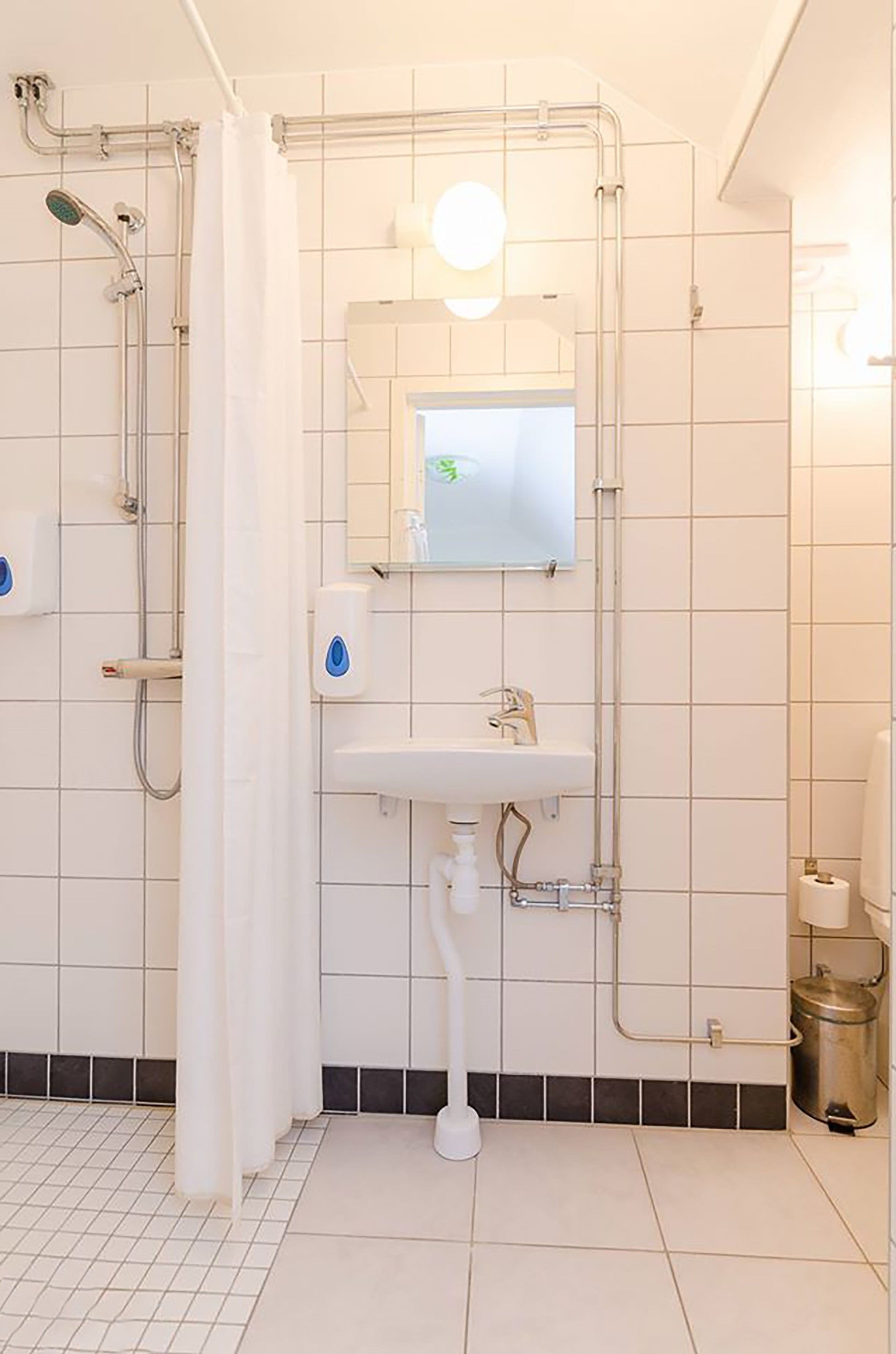 A bathroom with a shower, a sink, and a mirror.