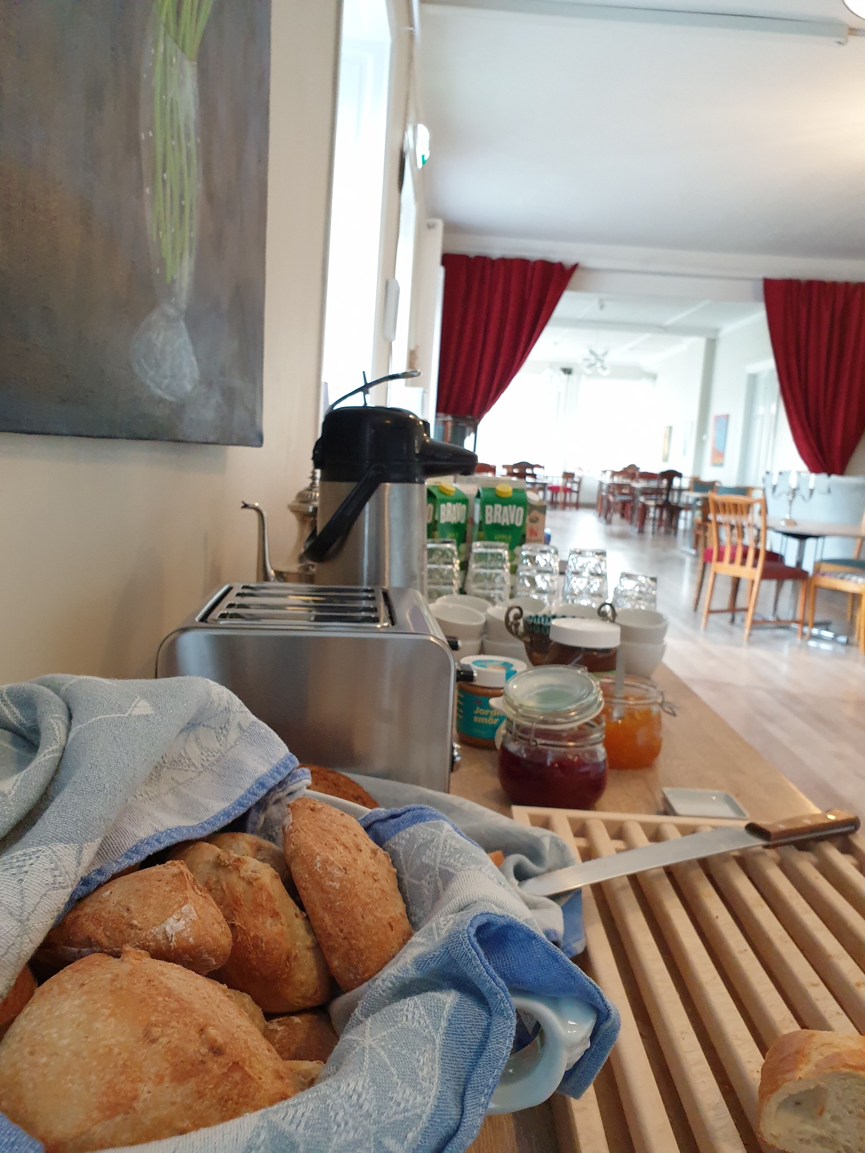 A breakfast setup with bread, a toaster, and condiments.