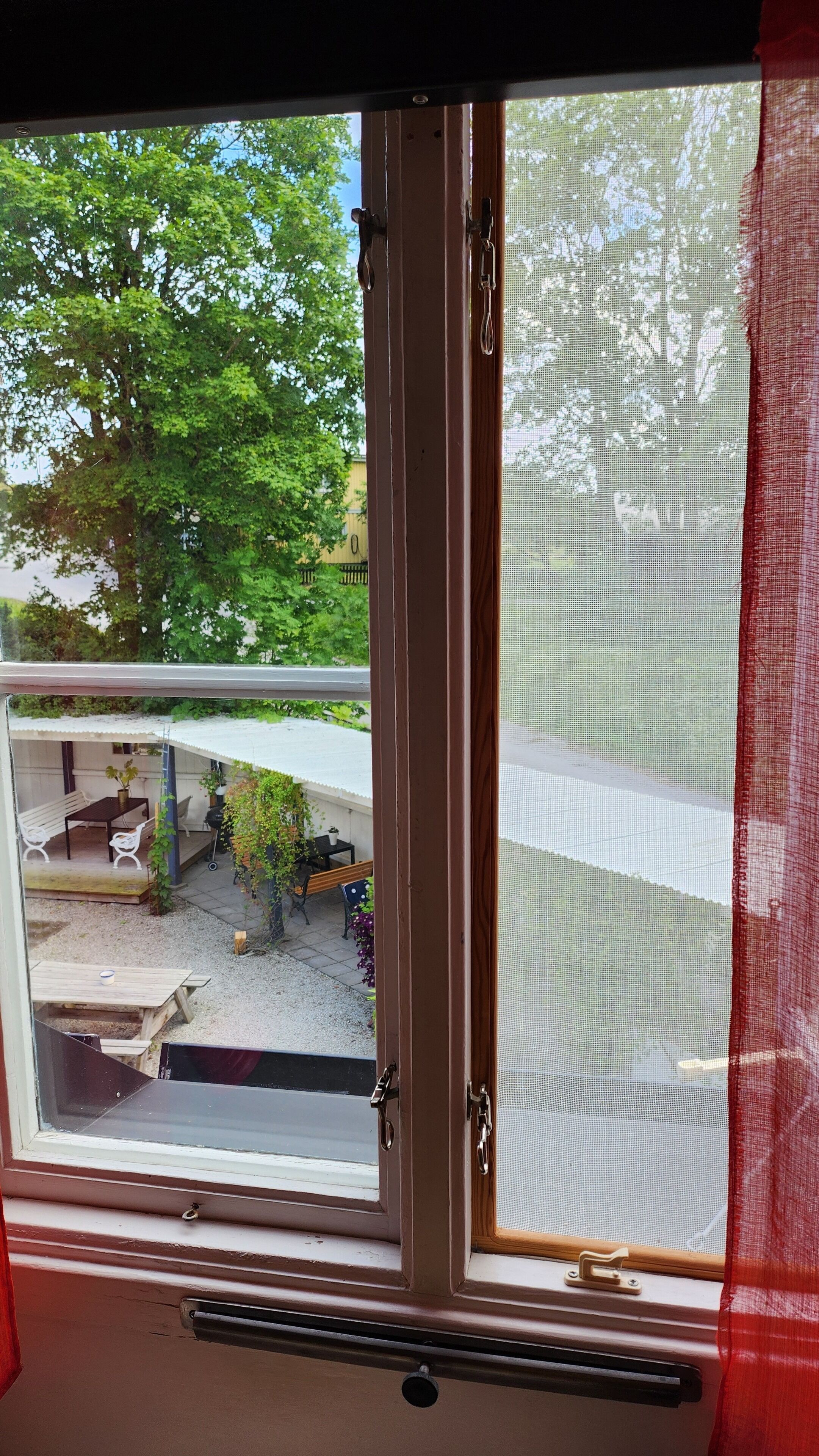 A window with a view of an outdoor patio area, including a table and chairs.