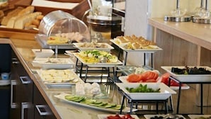 A buffet with various food items and a glass display case. - Zamek Gniew - Hotel Rycerski (Gniew)