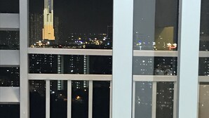Ein Nachtblick auf eine Stadtlandschaft, im Hintergrund ein markantes, beleuchtetes Hochhaus.