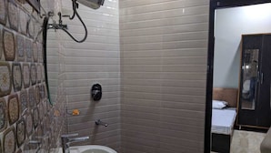 A small bathroom with a sink, a towel rack, and a shower area.