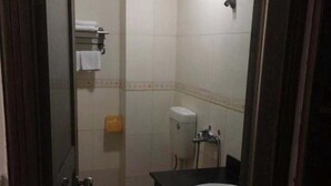 A small, compact bathroom with a toilet, sink, and a towel rack. - ruixing hotel (Yangjiang)