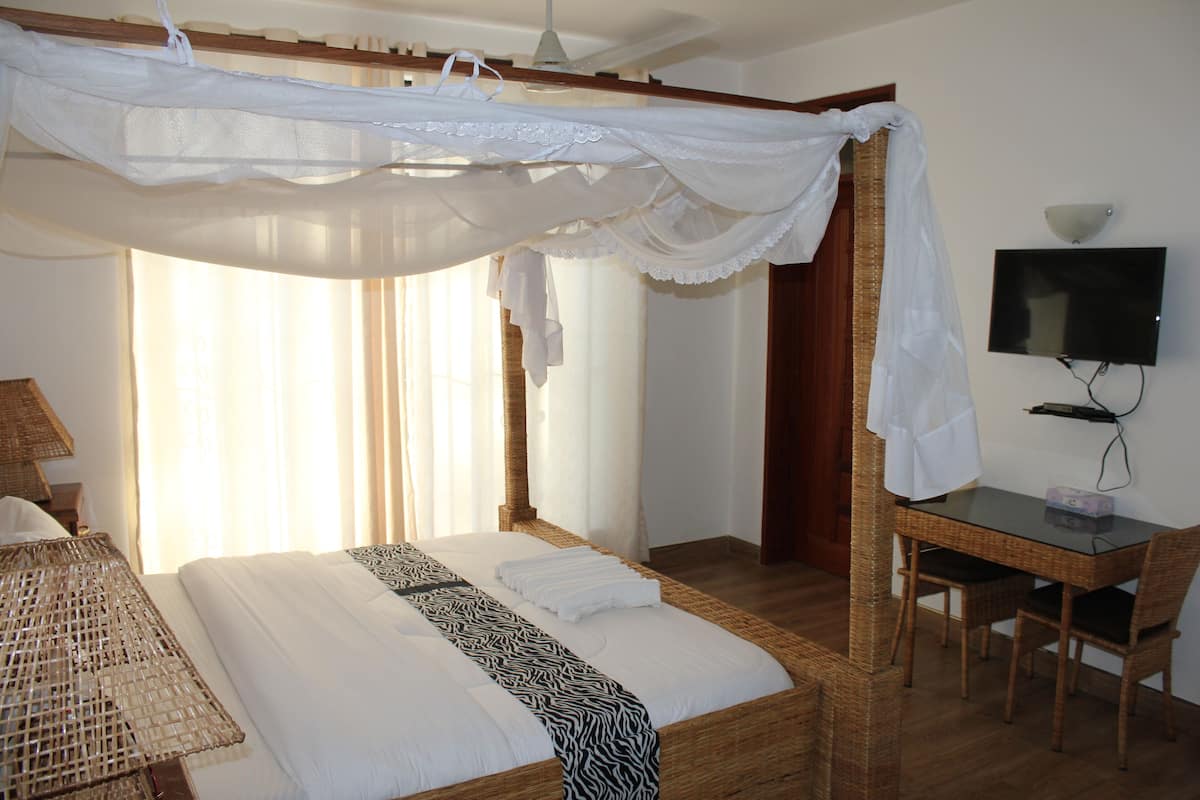 Una camera da letto con un letto, una scrivania, una sedia e una televisione.