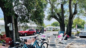 A paved sidewalk with bicycles, outdoor seating, and parked cars. - The Inn at Southport (Southport)