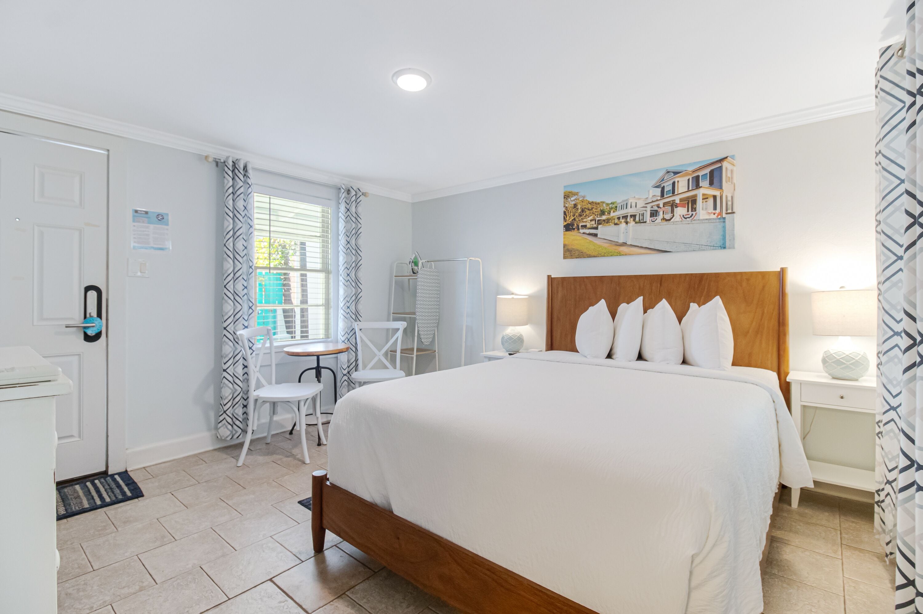 A bedroom with a large bed, a desk, and a chair.