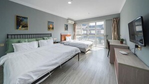 Ein modernes Hotelzimmer mit zwei Betten, einem Schreibtisch, einem Fernseher und großen Fenstern.