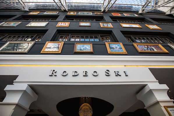 Exterior del hotel RODEOSKI con múltiples obras de arte enmarcadas en la fachada y un diseño arquitectónico moderno y geométrico.