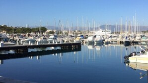 Un port de plaisance où de nombreux bateaux sont amarrés, l’eau est calme et le ciel est dégagé.