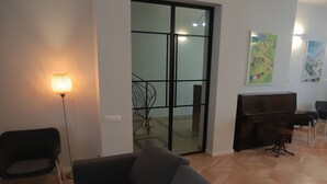 Una sala de estar moderna con un sofá, una lámpara de pie y un piano.