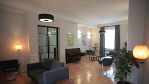 Un amplio salón con un piano, sofás y un comedor.