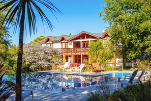 A resort with a swimming pool, lounge chairs, and a large building with multiple balconies. - Shemak Posada (Villa General Belgrano)