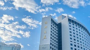 Um edifício moderno com uma placa vertical chamativa.