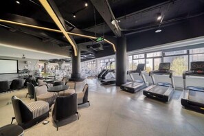 A gym with treadmills, exercise balls, and seating areas.