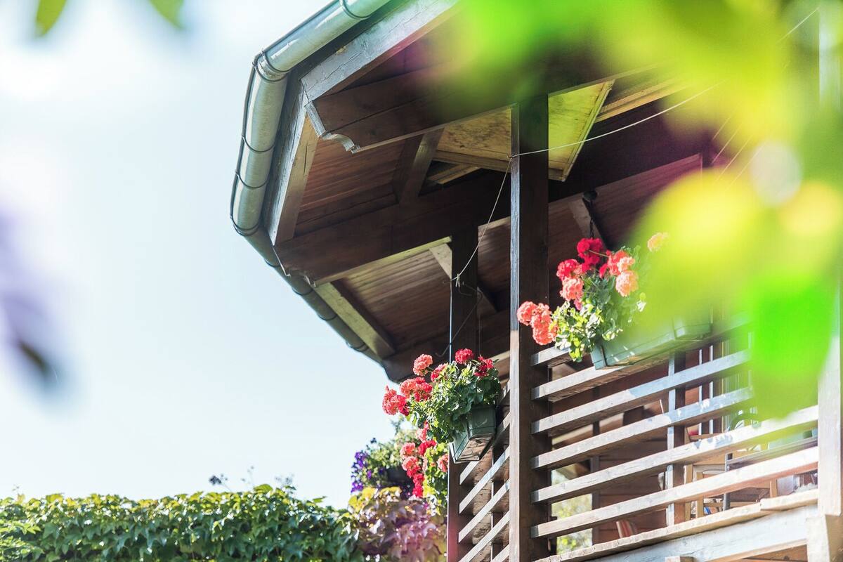 Ein Holzbalkon mit hängenden Blumenkörben.