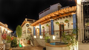 Un patio con piscina, plantas en macetas y una escalera que lleva a un segundo piso.