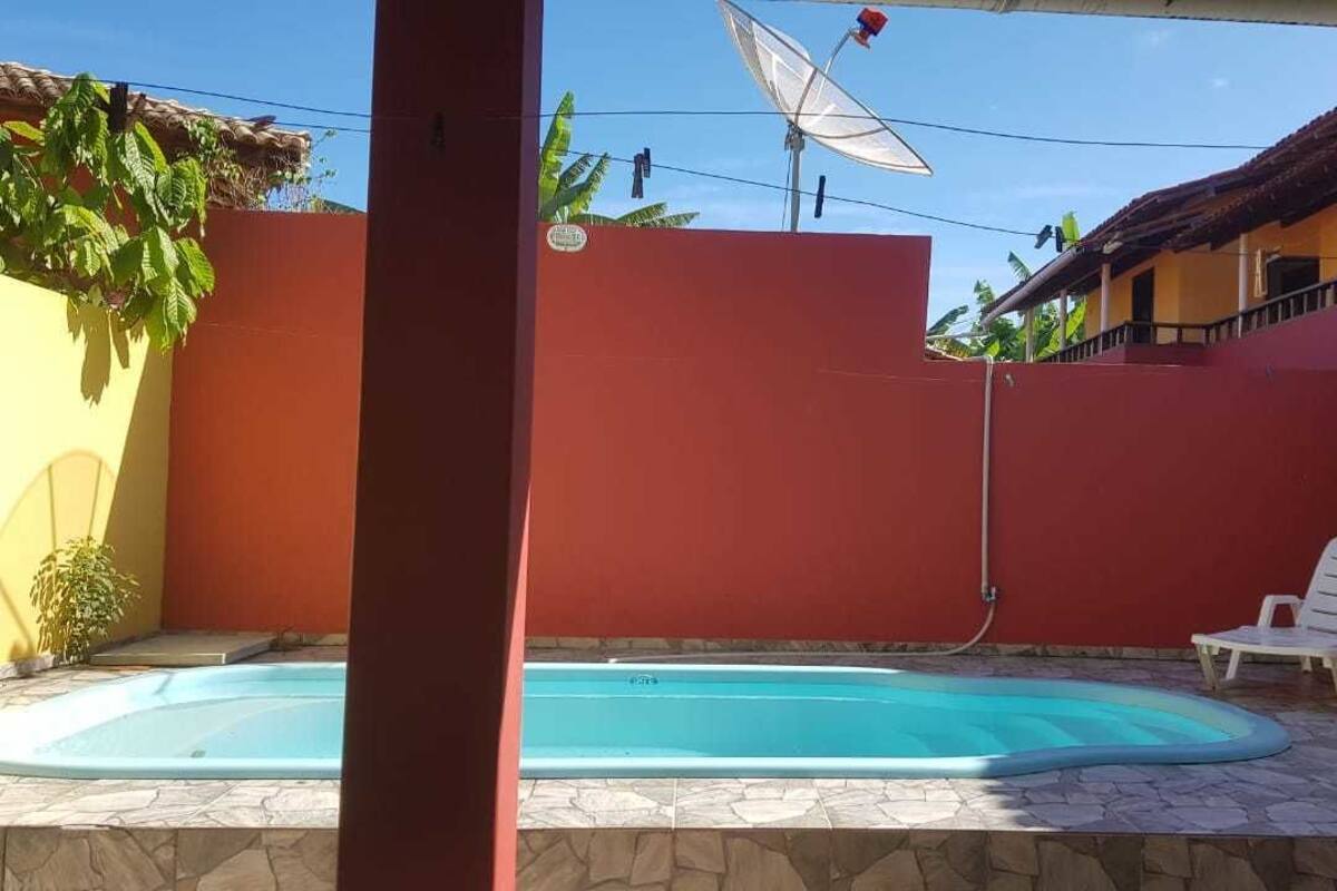 Ein Swimmingpool mit roter Wand und weißem Stuhl.