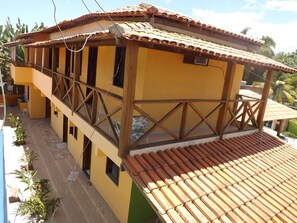 Un edificio de dos pisos con fachada amarilla y techo de tejas.