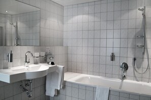 A modern bathroom with a bathtub, a sink, and a shower.