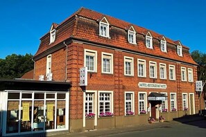 A red-brick building with a sign reading 'HOTEL-RESTAURANT-WITTE' and multiple windows with flower boxes.