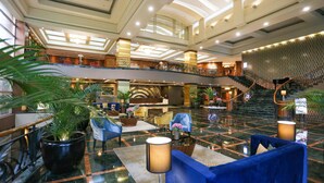 A spacious lobby with a grand staircase, multiple seating areas, and a high ceiling with skylights. - Wyndham Casablanca Jakarta (Jakarta)