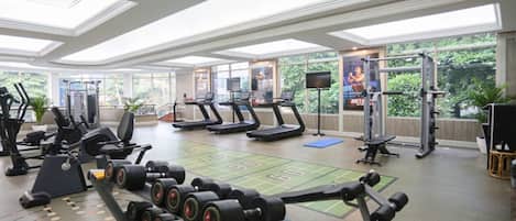 Ein Fitnessstudio mit Laufbändern, Kraftgeräten und Hanteln.
