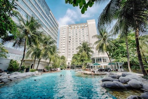 A hotel pool surrounded by palm trees and modern buildings. - Wyndham Casablanca Jakarta (Jakarta)