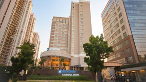 Un hotel de gran altura con un llamativo letrero 'WYNDHAM', rodeado de otros edificios altos.
