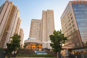 Un hotel de gran altura con un llamativo letrero 'WYNDHAM', rodeado de otros edificios altos.